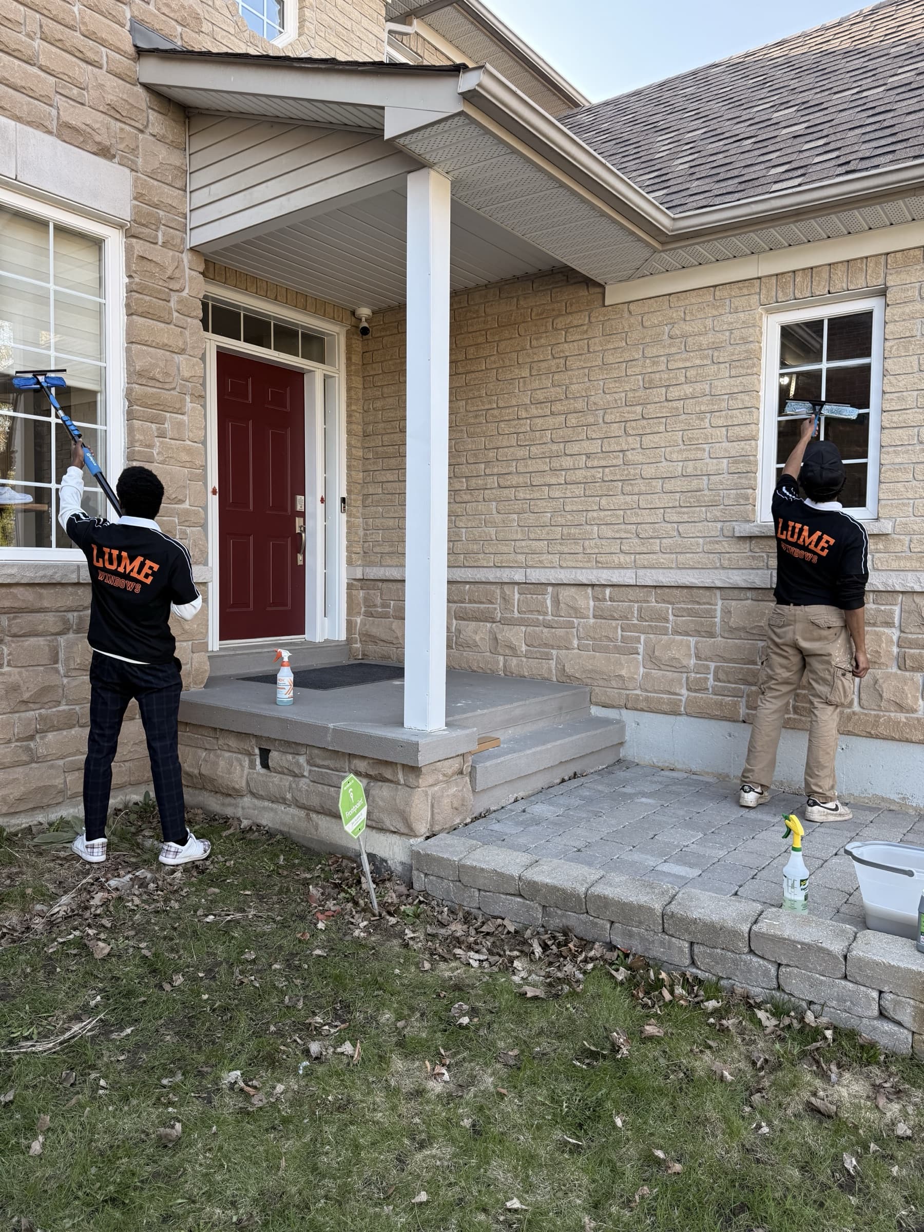 Two Lume Windows crew members cleaning exterior windows on a residential home